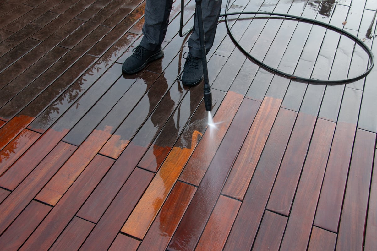 High-pressure washing and cleaning a wooden deck at a coastal home